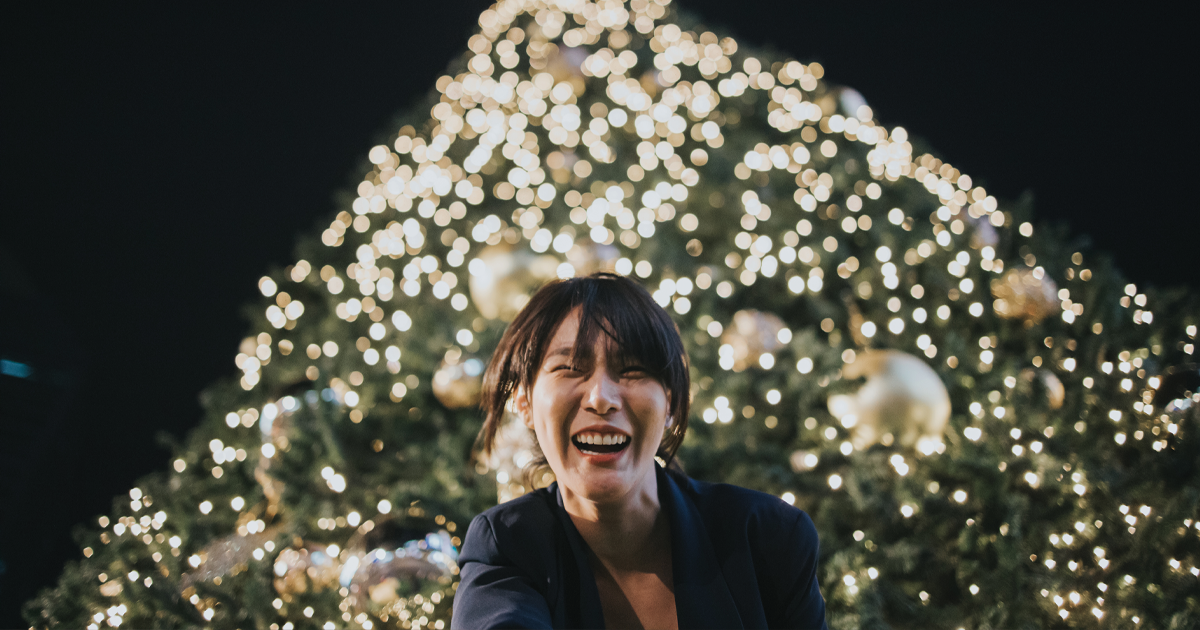 woman smiling by Christmas tree