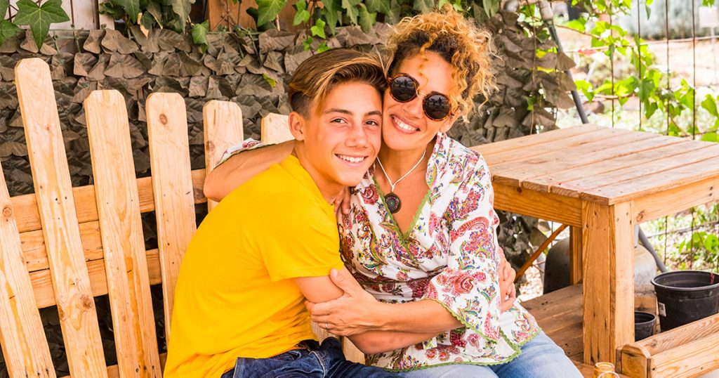 son and mother hugging on bench